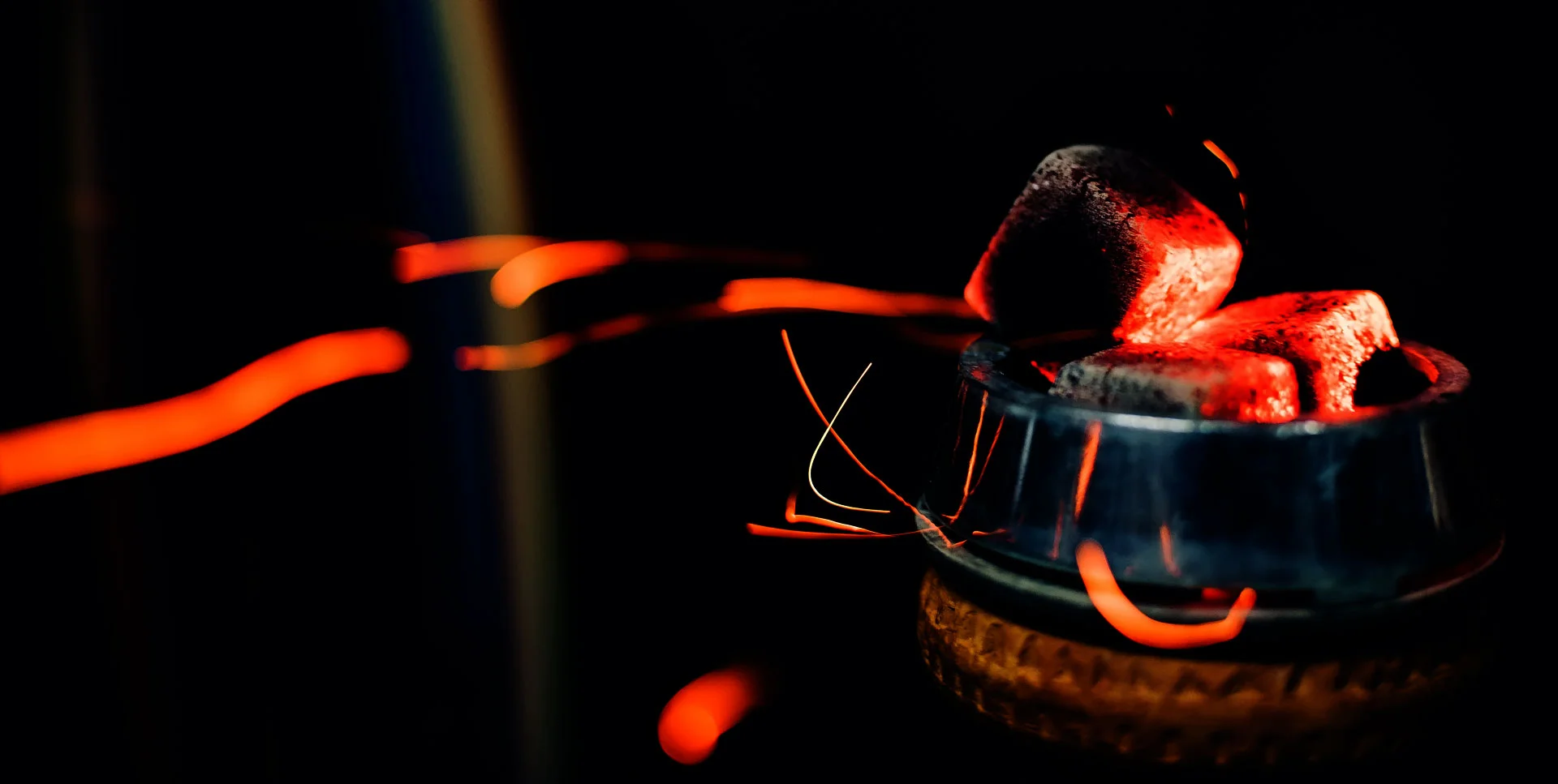 Hookah bowl with coals for tobacco Close-up of smoking with sparks on a dark background